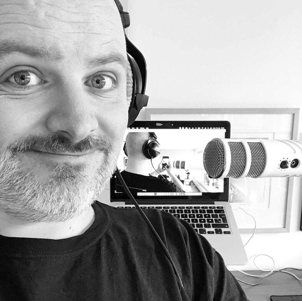 billedet viser Per Andreasen foran sin computer og podcast-mikrofon